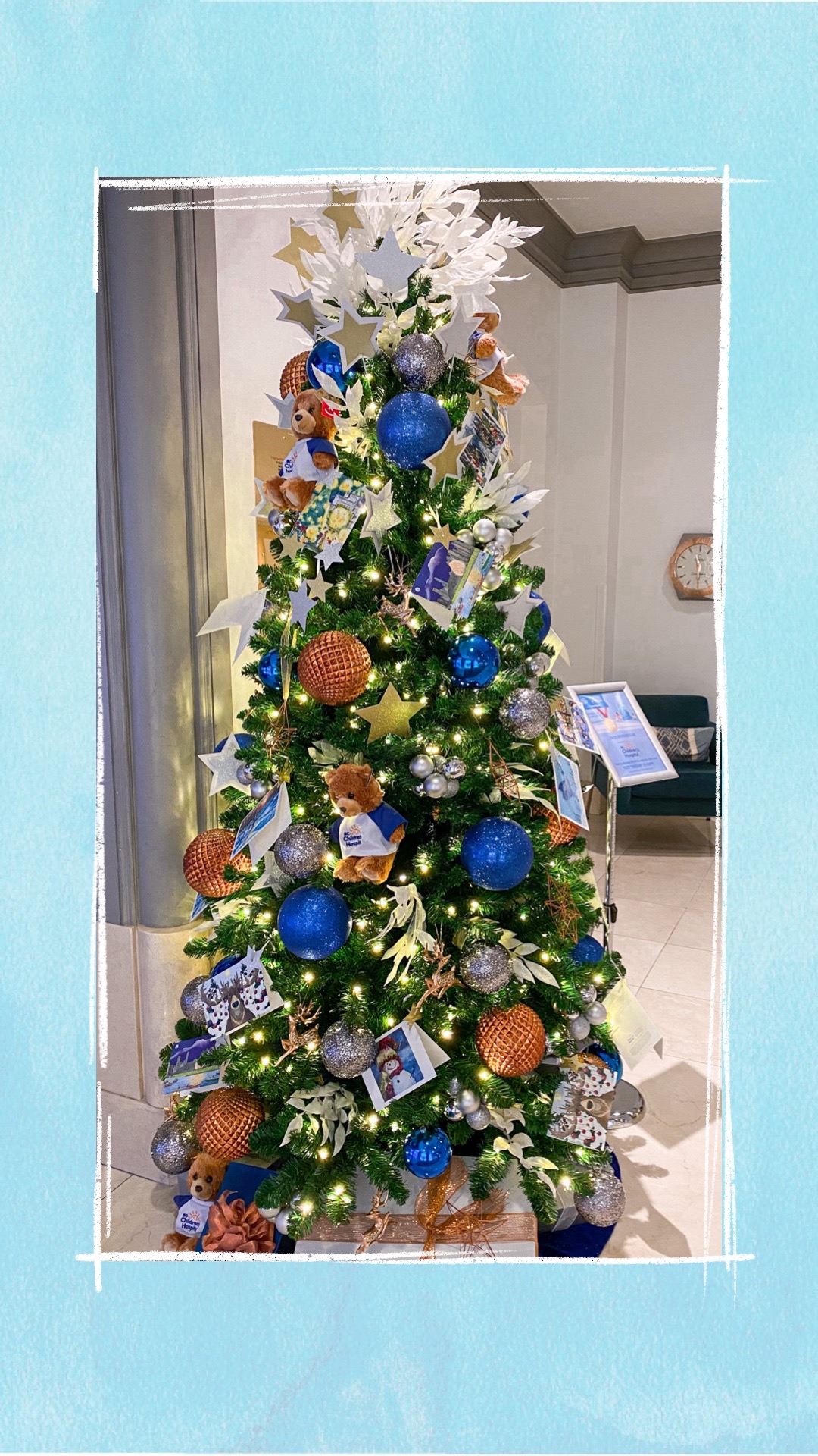 A holiday tree decorated with blue and copper ornaments for the BCCHF Festival of Trees