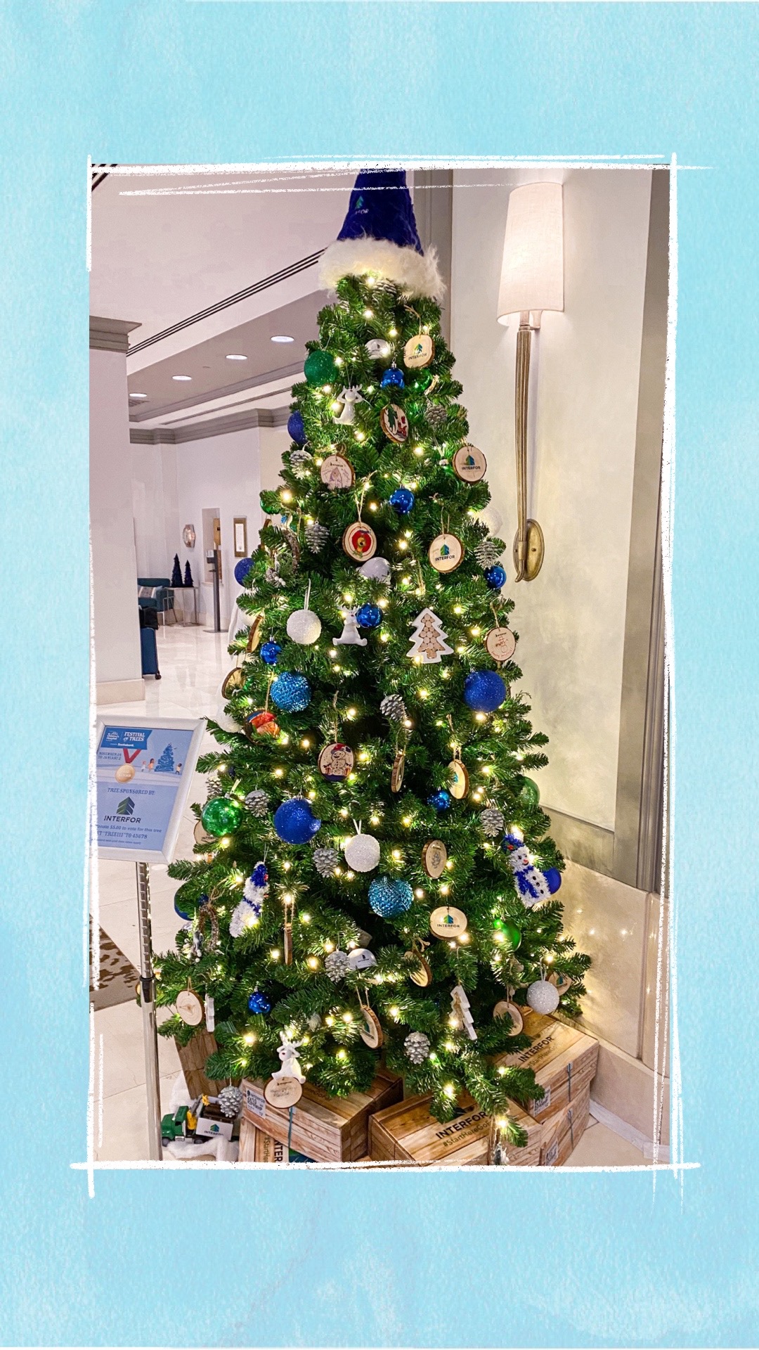 A holiday tree decorated with blue and silver ornaments for the BCCHF Festival of Trees