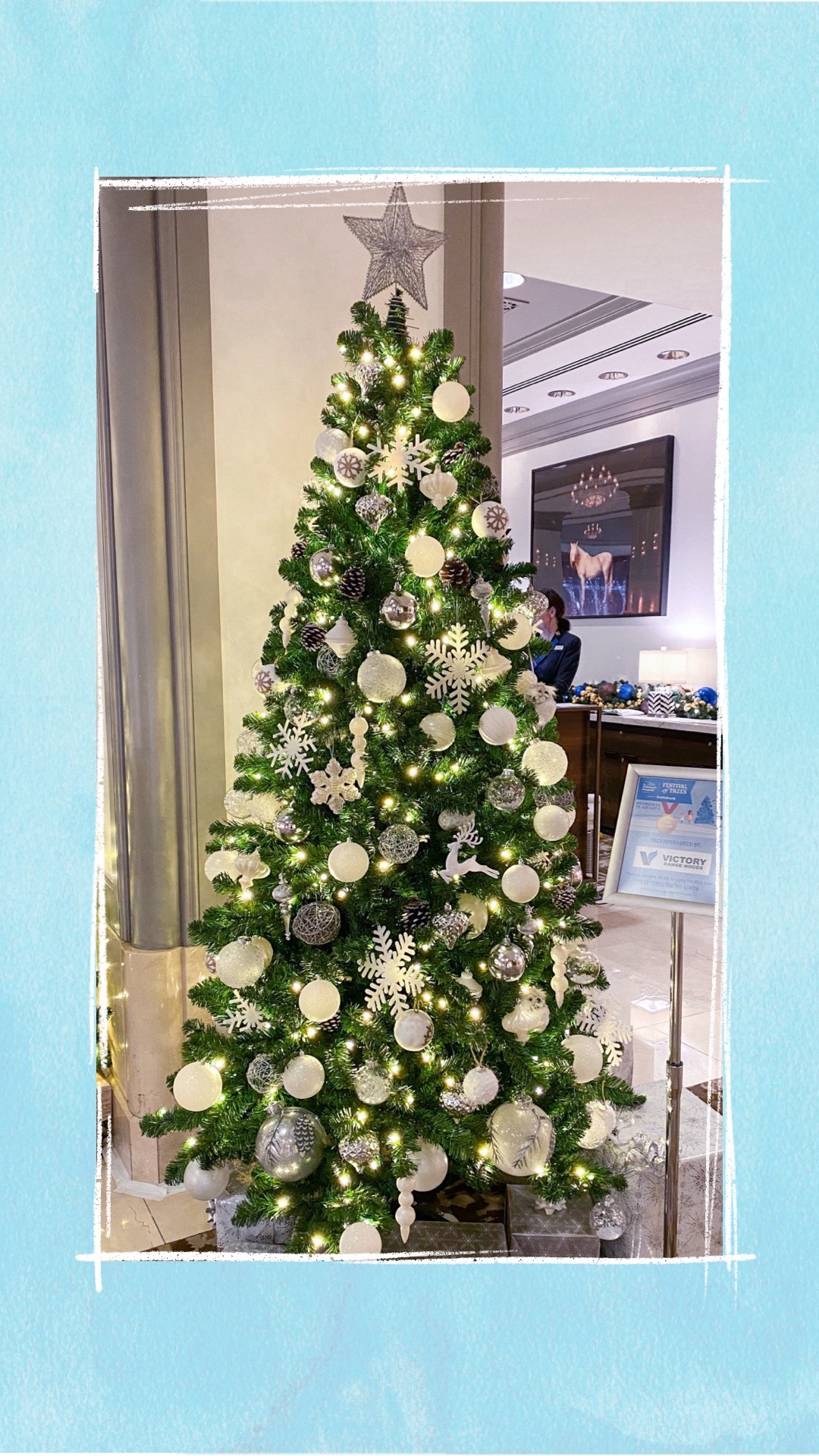 A holiday tree decorated with white and silver ornaments for the BCCHF Festival of Trees
