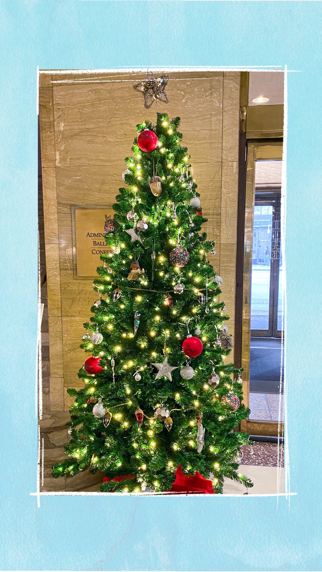 A holiday tree decorated with red and silver ornaments for the BCCHF Festival of Trees