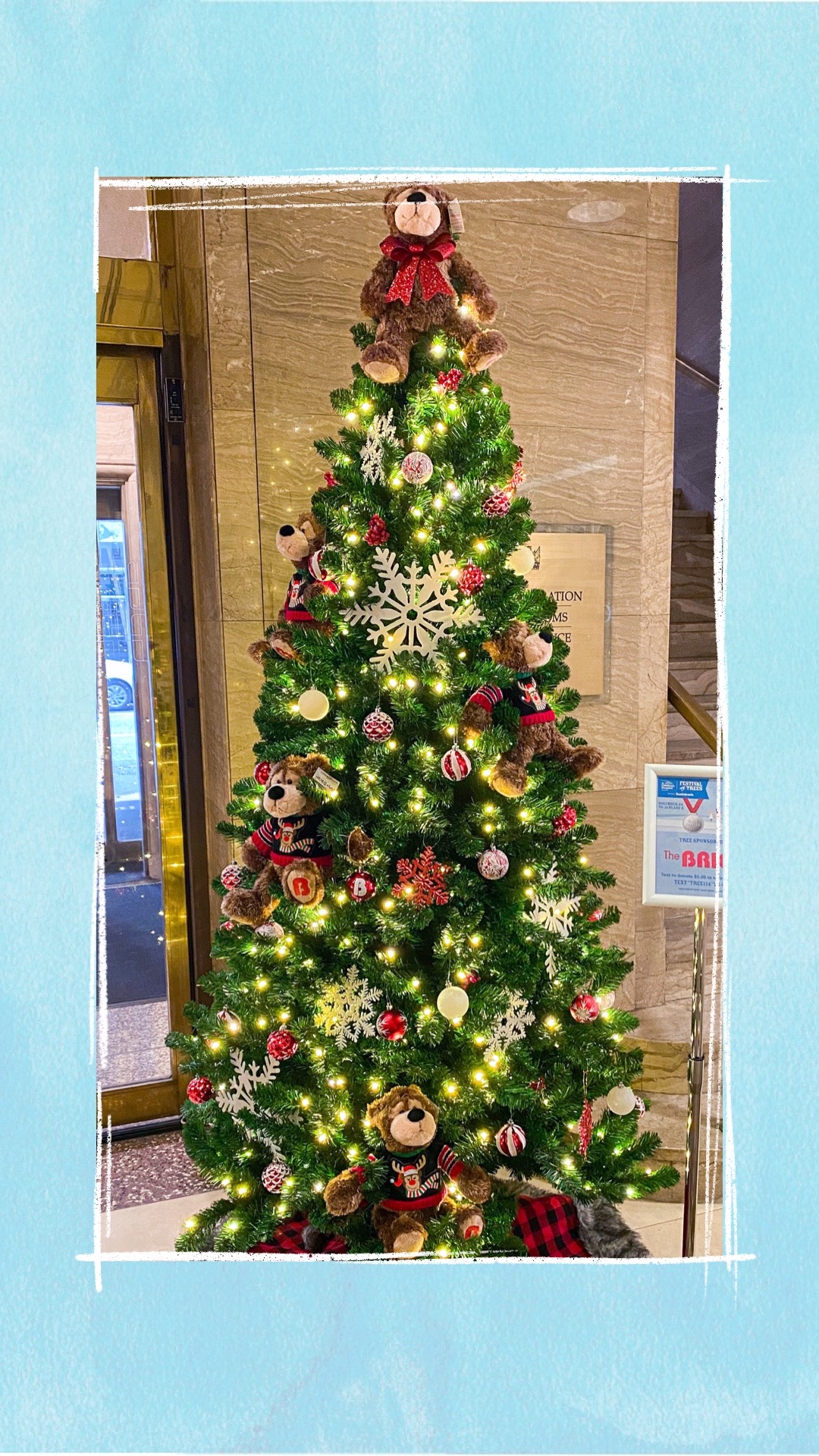 A holiday tree decorated with red and white ornaments and teddy bears for the BCCHF Festival of Trees