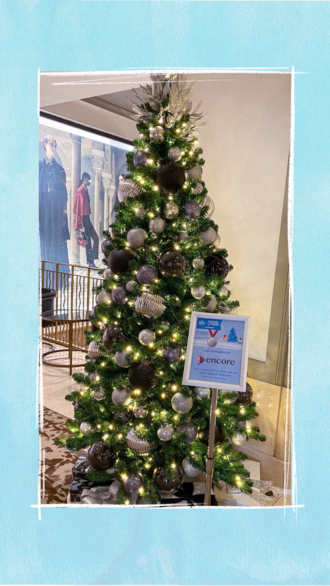 A holiday tree decorated with black and silver ornaments for the BCCHF Festival of Trees