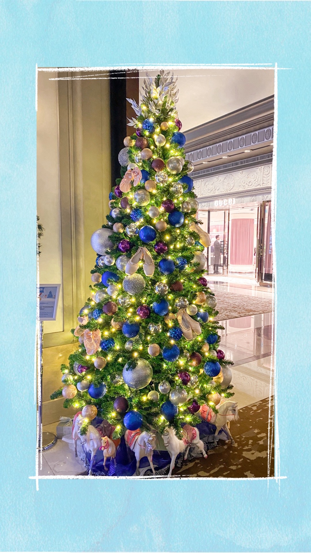 A holiday tree decorated with blue, purple, and silver ornaments for the BCCHF Festival of Trees