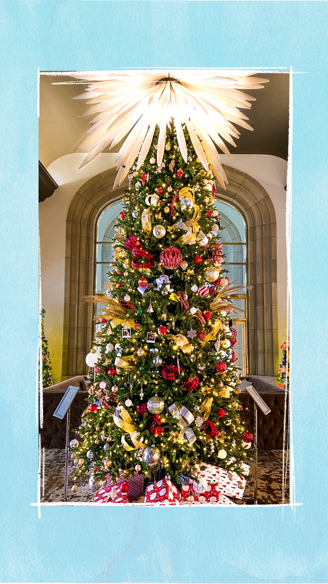 A holiday tree decorated with red and gold ornaments for the BCCHF Festival of Trees