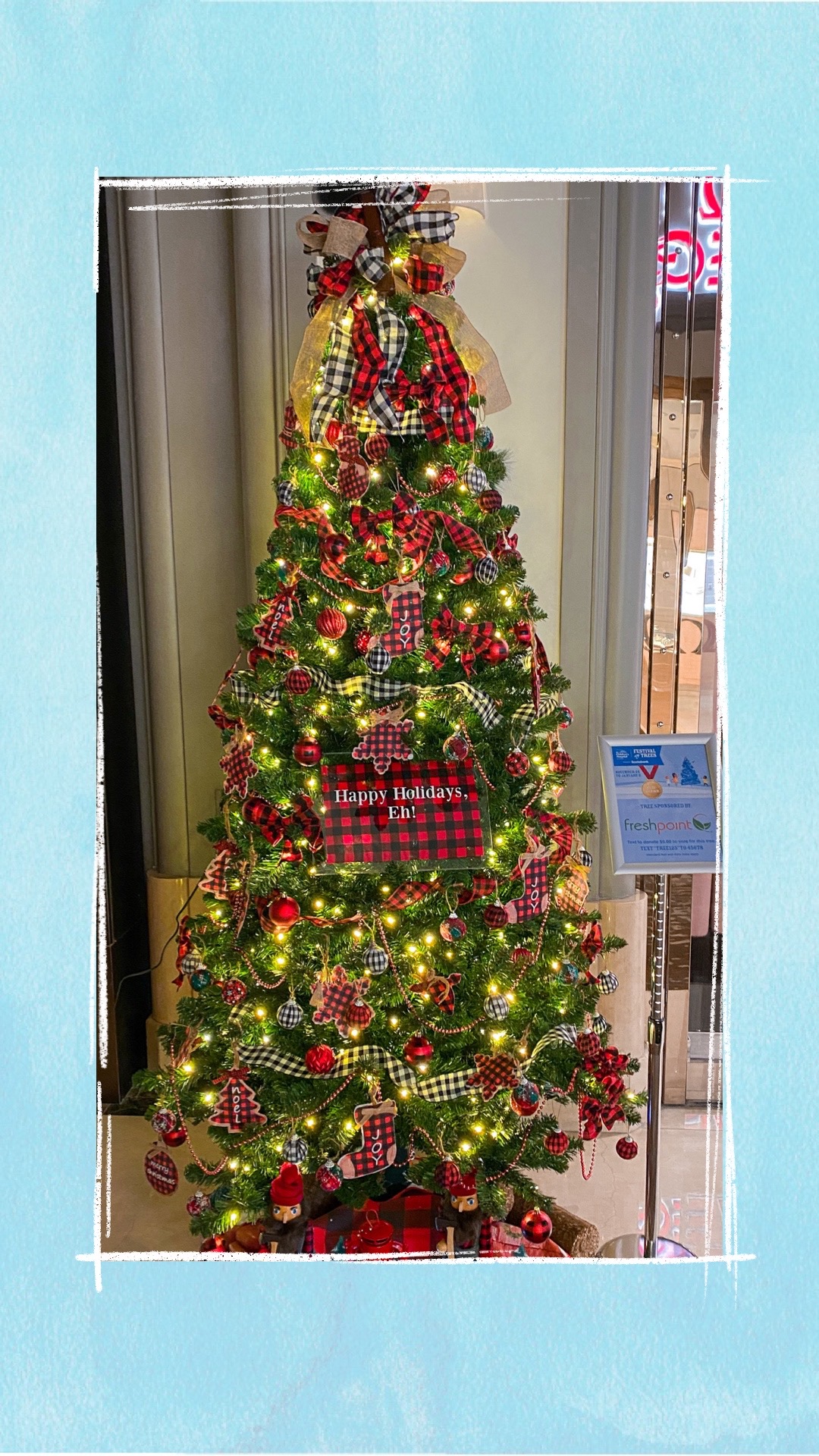 A holiday tree decorated with red and black plaid ornaments for the BCCHF Festival of Trees