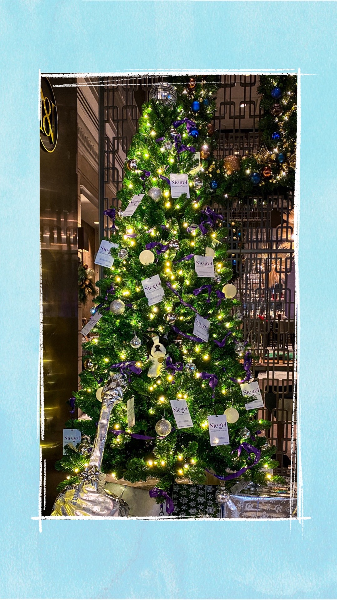 A holiday tree decorated with purple and silver ornaments for the BCCHF Festival of Trees