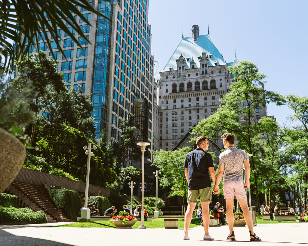Male couple holding hands in front of Fairmont Hotel Vancouver
